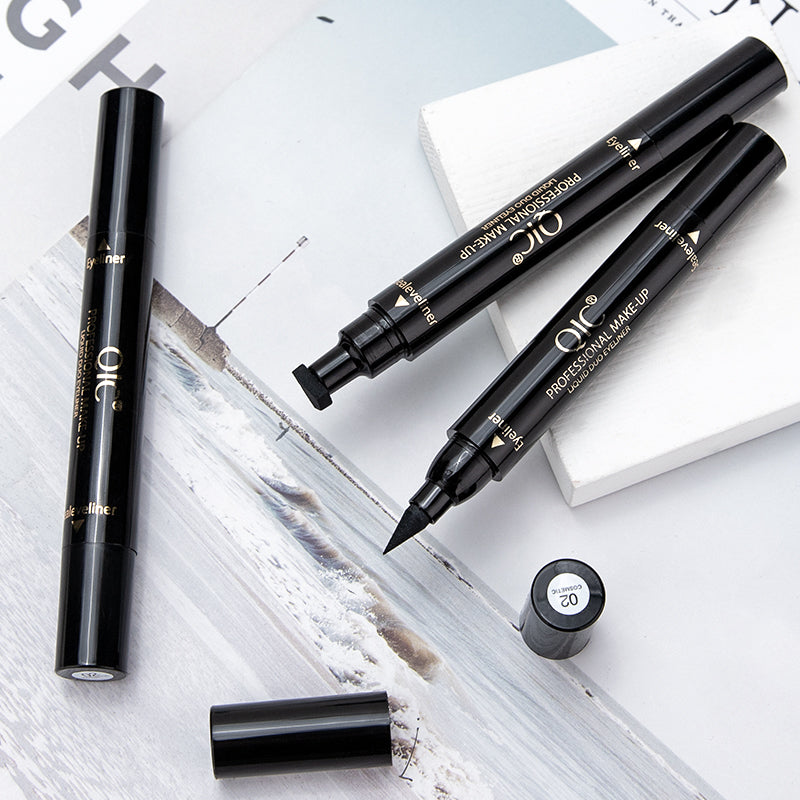 Flat lay of 2-Swipe Cat Eye Hack Dual-Ended Magic Wand with caps off, showcasing waterproof stamp and eyeliner tips for bold eye makeup.