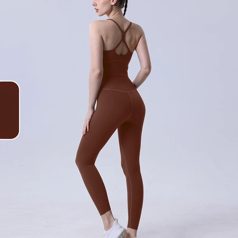 Brown women's activewear set with cross-back sports bra and matching leggings, designed for yoga and gym sessions.