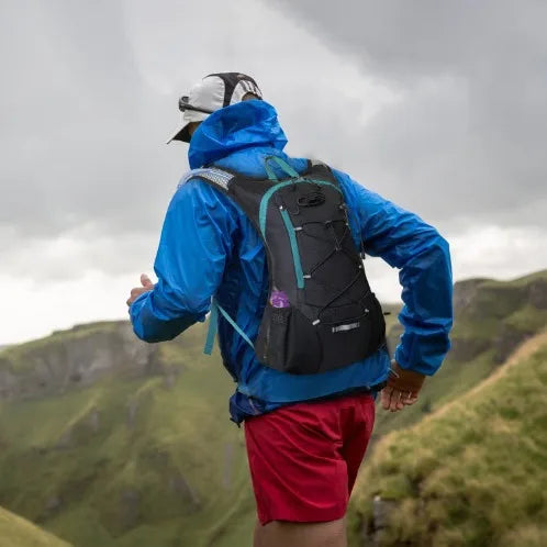 Man trail running with black hydration pack featuring 2L bladder and ergonomic fit, perfect for outdoor endurance sports.