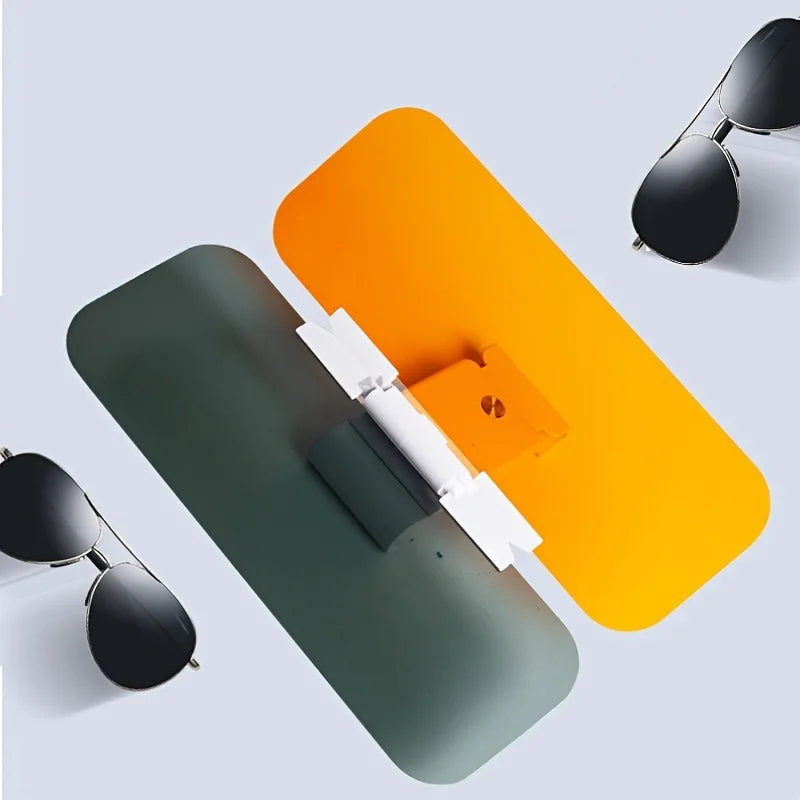 Top view of dual-panel car sun visor glare shield with yellow and gray lenses, placed next to sunglasses for size and function comparison.