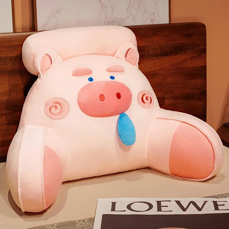 Pink pig cartoon backrest pillow with blue tongue and red snout, offering lumbar support and fun decor for sofas or beds.